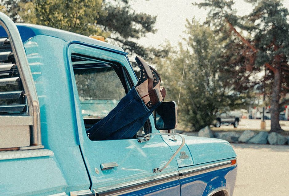 boots sticking out a truck window